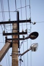 Old stone pillar with wires and broken lamp on the blue sky background Royalty Free Stock Photo