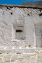 Old stone and plaster whitewashed exterior of building with sign pointing way of a walk to town of Monh