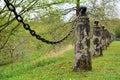 Old stone posts with an iron chain link fence