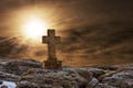 Old Stone Religious Cross on a Dark Dramatic Cloudy Sky with Sun Rays Royalty Free Stock Photo