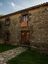 Old stone rock house with red yellow Senyera flag in historic town village of Tavertet Osona Catalonia Spain Pyrenees