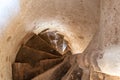 Old stone spiral staircase in a castle or old Church. Bottom view of the stairs and narrow passage. Historical value and culture Royalty Free Stock Photo