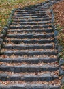 An old stone staircase going up. In autumn, the fallen leaves l Royalty Free Stock Photo