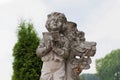 Old stone statue: angel boy with bible near the cross. child loss concept Royalty Free Stock Photo