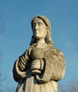 Old stone statue of a woman with a cup for Holy Communion on the Royalty Free Stock Photo