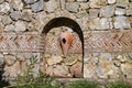 Old stone structure with urns built into a stone wall in the gardens of a restaurant in Turkey