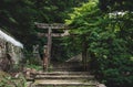 Old stone torri gate over a stairs path in park on Mount Misen in Miyajima, Hiroshima, Japan Royalty Free Stock Photo