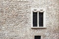 Old stone wall and cement with old window. Stone background. Krakow stone wall. Griddles on the windows. Krakow building Royalty Free Stock Photo