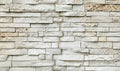 Old stone wall cladding made of horizontal white bricks with brown spots, of natural rock stacked Royalty Free Stock Photo