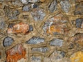 Old stone wall close up in orange beige blue grey palette. Stone tile with cement joints background with detailed Royalty Free Stock Photo