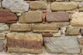 Old stone wall made of various square natural stones in beige, ocher, red and brown. Stone wall texture background Royalty Free Stock Photo
