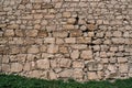 Old stone wall texture with green grass, blocks of ancient castle surface as background for design Royalty Free Stock Photo