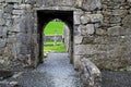 Old stone walls and archways leading to gravestones in old cemetery Royalty Free Stock Photo