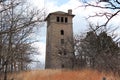 Old stone watch tower with sky and an winter trees