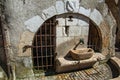 Old stone water fountain with iron gates and heraldic shield on the arch in Annecy.