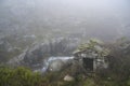 Old stone water mill. Mountain fresh water stream. Foggy day. Freita mountain range