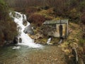 An old stone water mill near a waterfall in an autumn forest Royalty Free Stock Photo