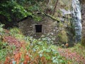 An old stone water mill near a waterfall in an autumn forest Royalty Free Stock Photo