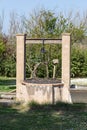 Old stone water well ruined on a green rural landscape Royalty Free Stock Photo