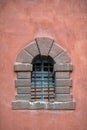 Old stone window in castle. Metal bars on window. Vertical frame