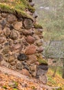 Old stones overgrown with moss and lichens, stone wall from old castle ruins, autumn in the park