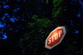 Old stop sign, obeying by european traffic regulations, lit during a dark night, indicating to all vehicles to stop and to yield