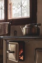 Old stove with open hatch and a kettle in a cabin
