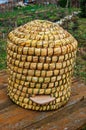 Old straw beehive standing on a wood table outdoors Royalty Free Stock Photo