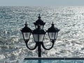 An old street lamp on the background of a stormy sea. Walking around the city. Royalty Free Stock Photo