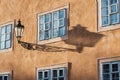 An old street lamp and shadow on a wall with a window Royalty Free Stock Photo