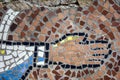 Old street mosaic with traces of destruction. Outstretched hand