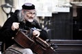 An old street musician playing the hurdy gurdy