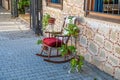 an old street stands a decorative rocking chair and left and right are green plants Royalty Free Stock Photo