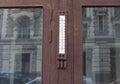 Old street thermometer on granite wall on the window of an old house in the center of the city