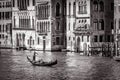 Old street in Venice in black and white. Gondola with tourists sails on Grand Canal