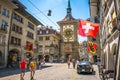 Old street view with tourists flags and Zytglogge clock tower in Kramgasse street in Bern old town Switzerland Royalty Free Stock Photo