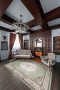 Old studying room with fabric armchairs and wooden table. Classic bookcase filled with books. Fireplace Royalty Free Stock Photo