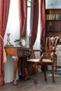 Old studying room with fabric armchairs and wooden table. Classic bookcase filled with books. Fireplace Royalty Free Stock Photo