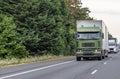 Old style cab over big rig semi truck transporting cargo in two dry van semi trailers running in front of another semi truck Royalty Free Stock Photo