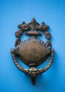 An old style decorative bronze door handle on a wooden azure door, the distinctive feature and symbol of Malta in Mdina. Royalty Free Stock Photo