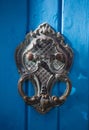 An old style decorative bronze door handle on a wooden azure door, the distinctive feature and symbol of Malta in Mdina. Royalty Free Stock Photo