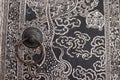 Old style iron door knob is on Thai painting ancient native door of church, Thailand. Royalty Free Stock Photo