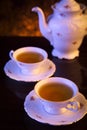 Old-style kettle with two cups of tea on black Royalty Free Stock Photo