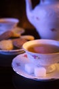 Old-style kettle with two cups of tea with cookies on black Royalty Free Stock Photo