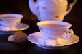 Old-style kettle with two cups of tea with cookies on black Royalty Free Stock Photo