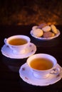 Old-style kettle with two cups of tea with cookies on black Royalty Free Stock Photo