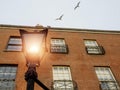 Old style lantern lamp in a street. Old red brick building in the background. Sea gull flying high in the air out of focus. City Royalty Free Stock Photo