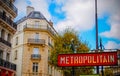 Old style Metro Sign in Paris with Architecture in background, France