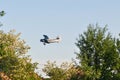 Old plane flying near the trees Royalty Free Stock Photo