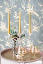 Old style retro candles and wine glass on a tray, vintage home decor on an a table, light tones Royalty Free Stock Photo